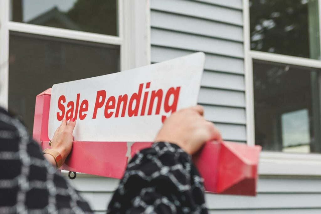 Person Holding a Signage Outside a House